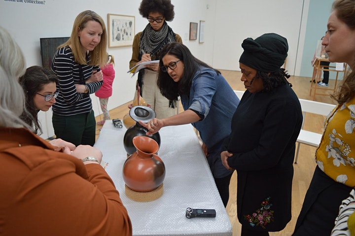 People looking at a ceramic object in a gallery