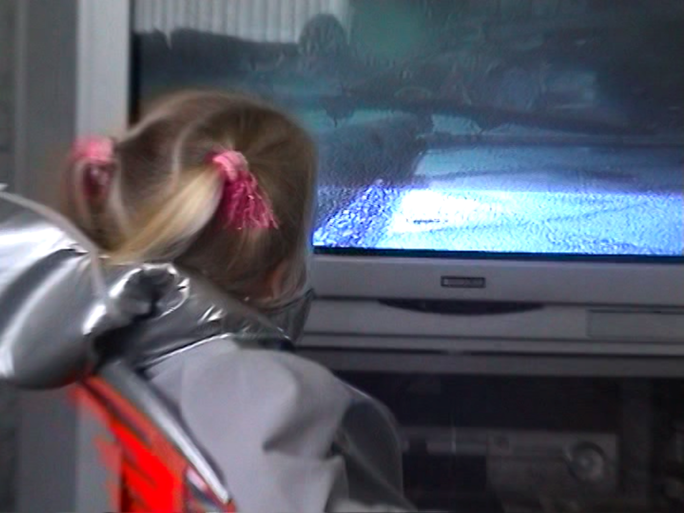 video still of a child looking at a TV screen