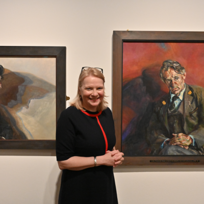 portrait photo of Susanna standing alongside paintings