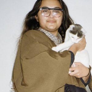 a portrait of Yas Lime holding a cat