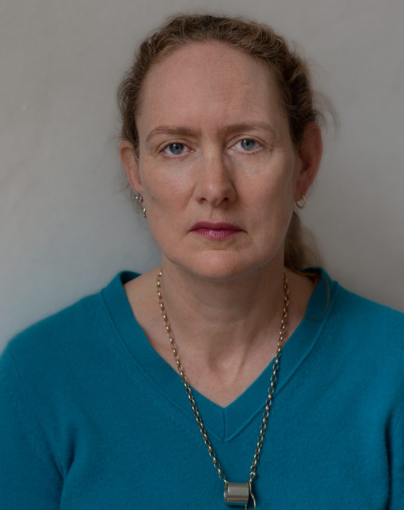 studio portrait photo of Clare, looking directly at camera, seriously
