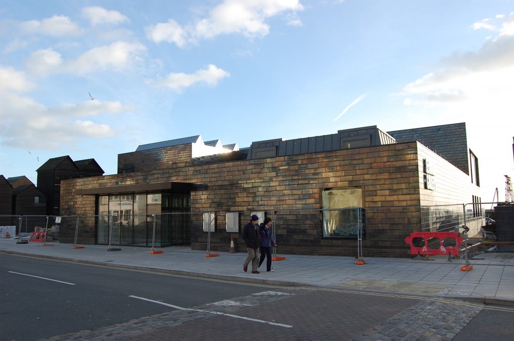 a street view of the modern art gallery, Jerwood, Hastings, barriers up indicating that the building is not yet open