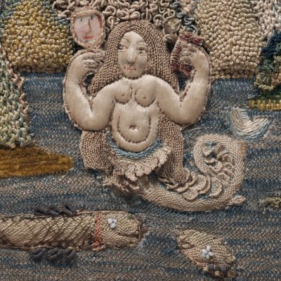 detail of a eighteenth century embroidery, with fantastical figures in high relief