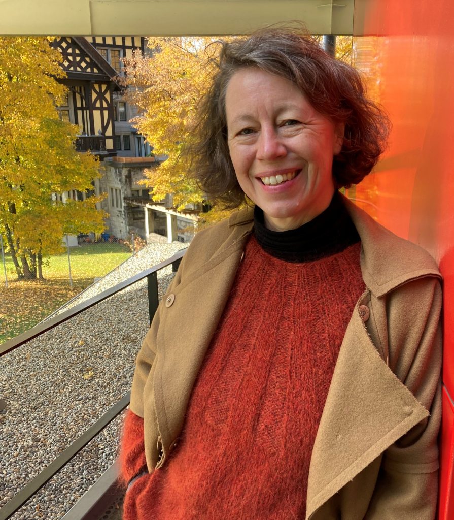 portrait photo of Bergit smiling broadly, in park setting, autumnal colours throughout