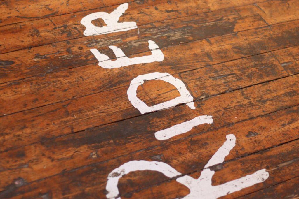 the word 'Rider' painted in white on wooden floorboards