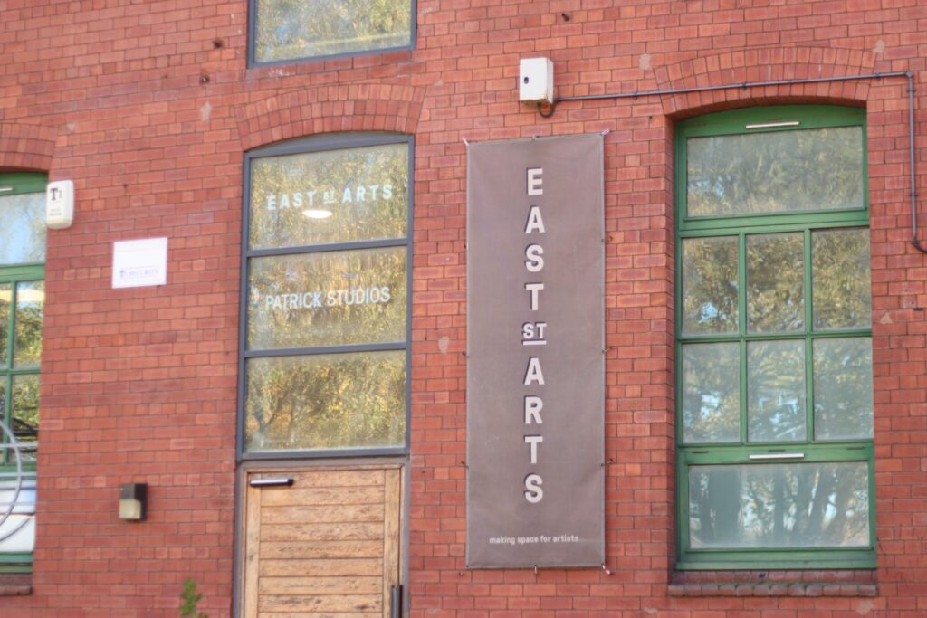 a banner reading 'East Street Arts: making space for artists' on the side of a red brick building. 
