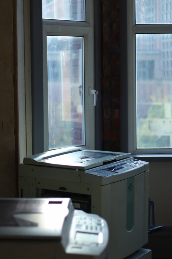 two riso printers by a bay window
