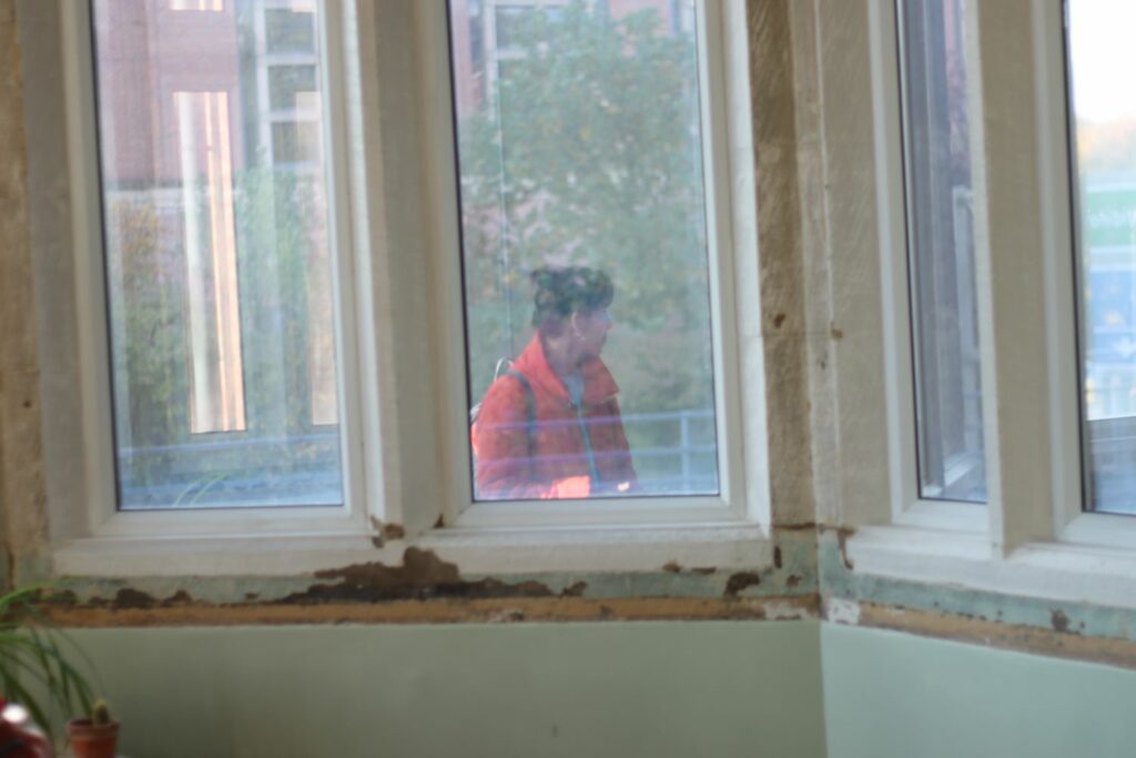 a person in an orange jacket seen through a window