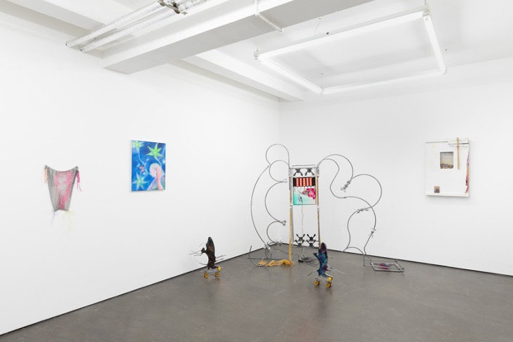 a white gallery space with several artworks